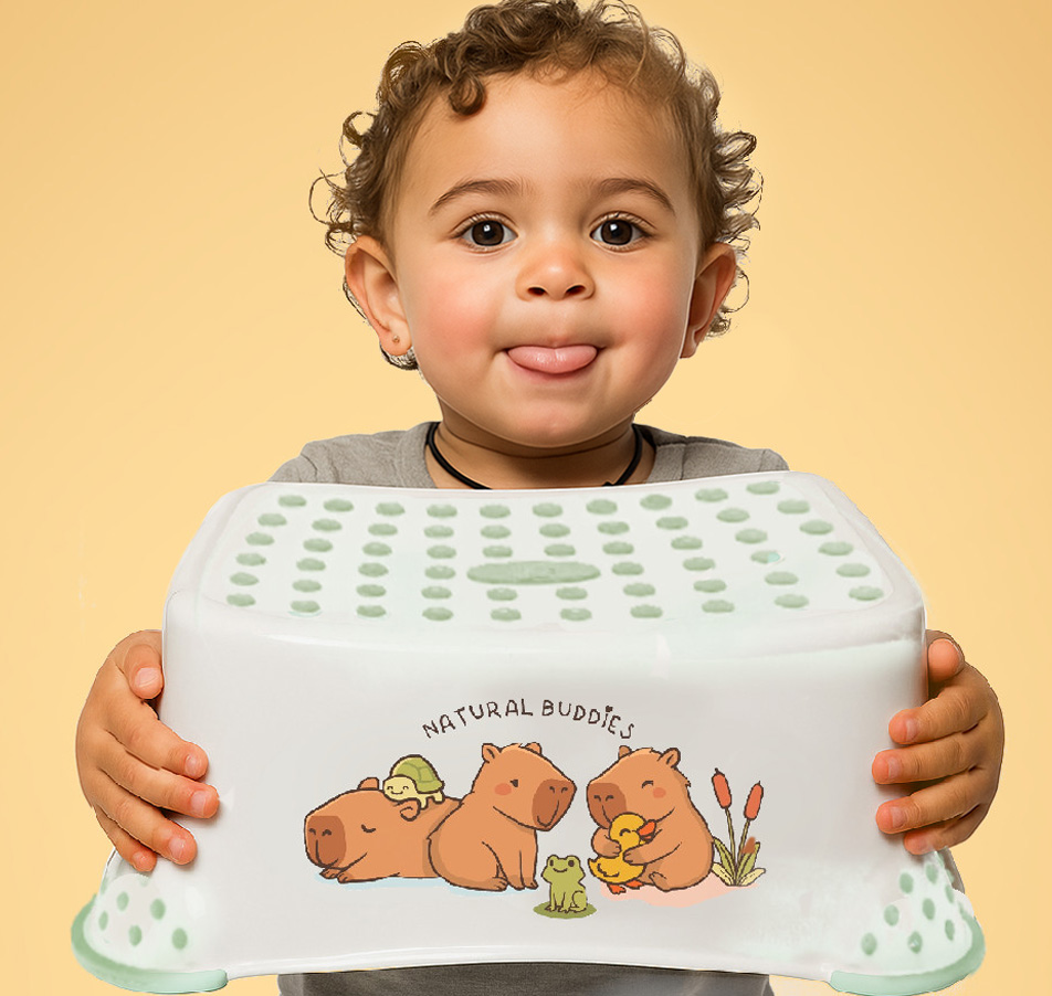 Toddler holding a children’s step stool with cute capybara artwork.