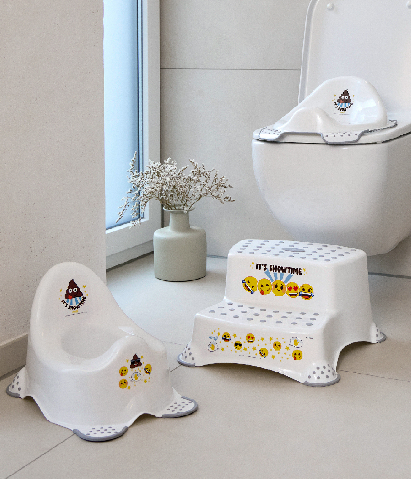 White potty training products for kids including potty, toilet seat, and step stool with emoji print.